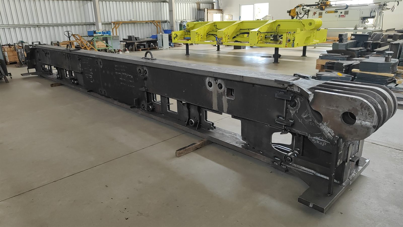 Long fabricated chassis weldment on the shop floor